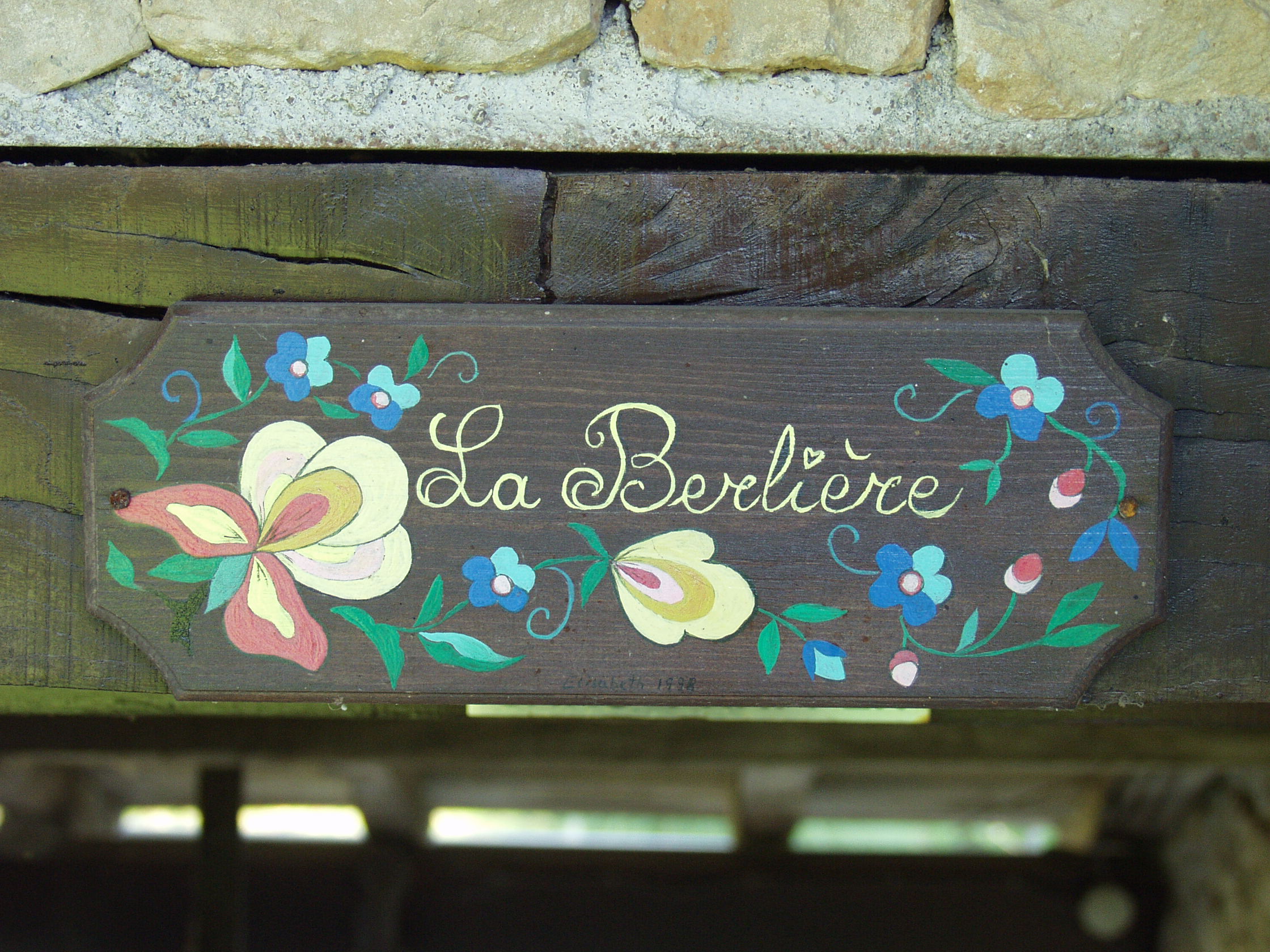 Petite pancarte au dessus de la porte d'entrée avec écrit La Berlière dessus avec des fleurs dessinées